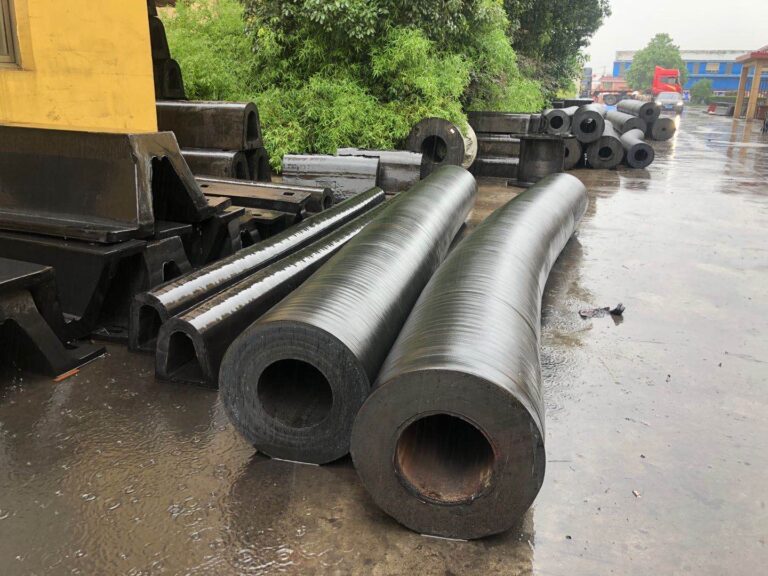 Cylindrical rubber fenders after rain in factory yard