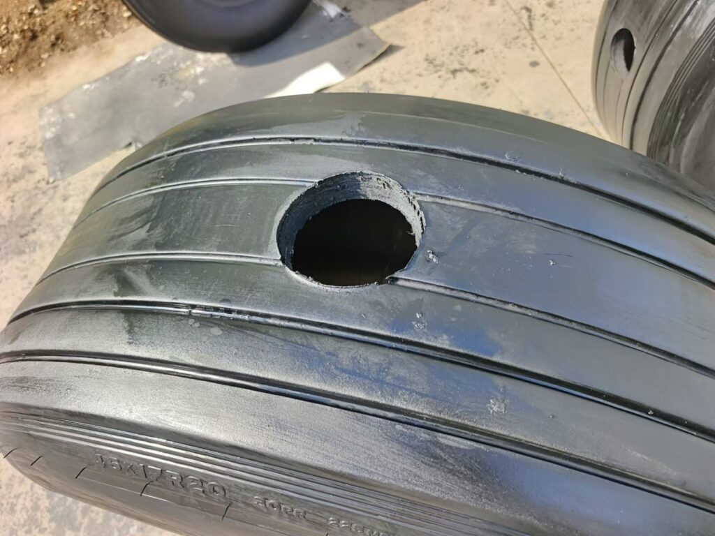 Custom-drilled aircraft tyre for pneumatic fender tire-chain net assembly