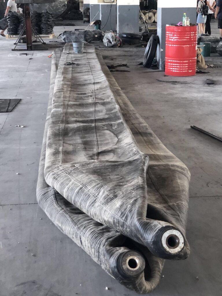 Deflated ship launch airbag showing end fitting and reinforced rubber body before inflation