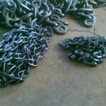 Marine anchor chain components and different chain sizes on workshop floor