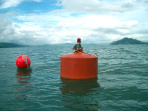 Red floating foam buoy in water for marine marking and mooring support