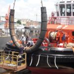 Grooved cylindrical rubber fender installation on a tugboat bow for marine protection